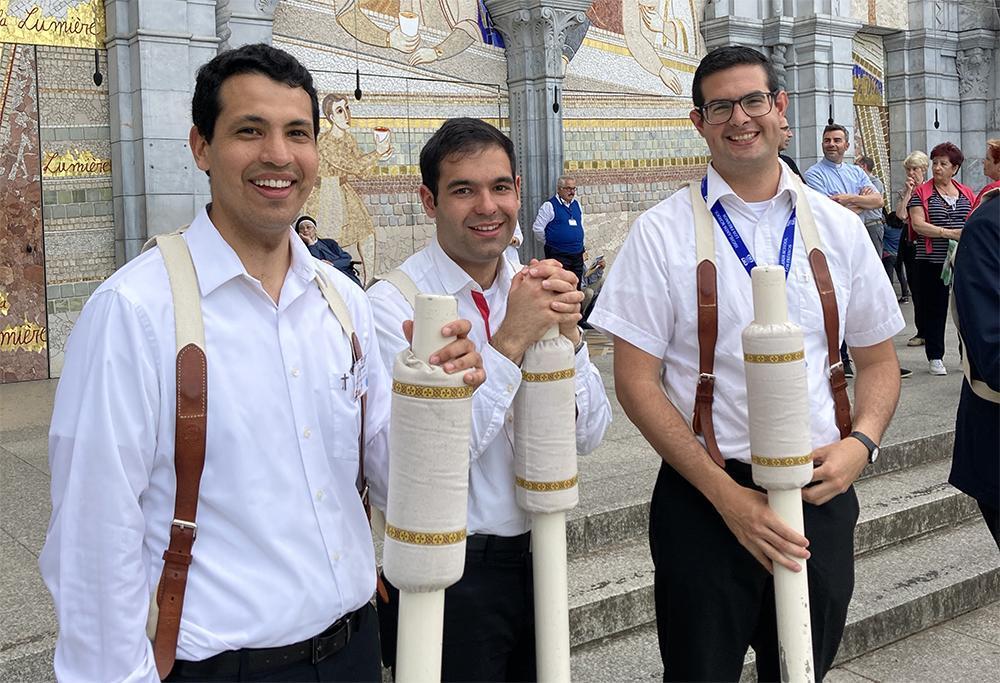 Tres novicios preparándose para la procesión de las antorchas.