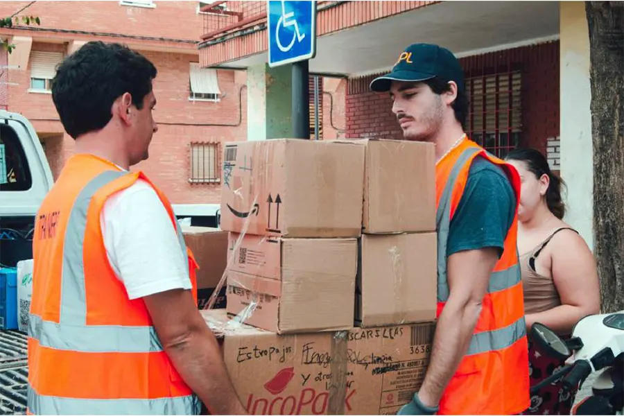 Dos voluntarios cargando cajas
